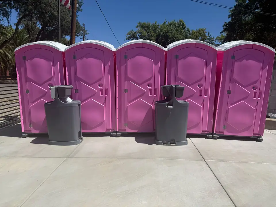 Row of portable restrooms with hand washing stations