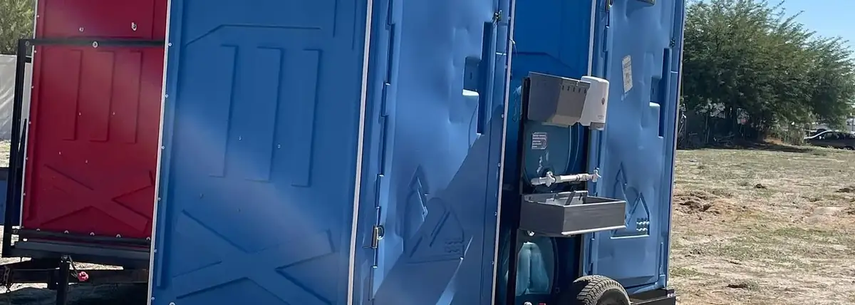 Porta potties strapped on a delivery trailer