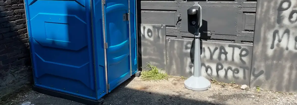 Porta potty and hand washing station beside a building