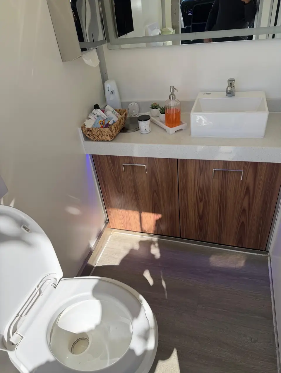 Restroom trailer interior with vanity sink, mirror and soft lighting